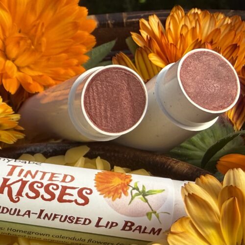 Vida Glow balms in bowl of calenedula flowers and showing tinted balm surface